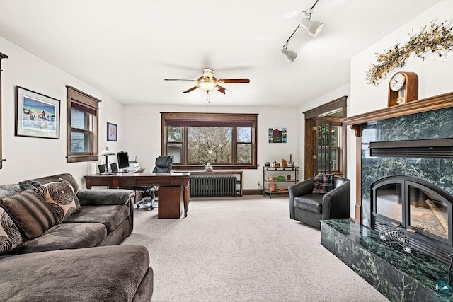 130 W Faribault St, Duluth, MN 55803 - living room with carpet flooring, track lighting, radiator, a ceiling fan, and a high end fireplace