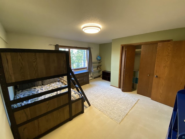 bedroom featuring a textured ceiling, light colored carpet, and a closet