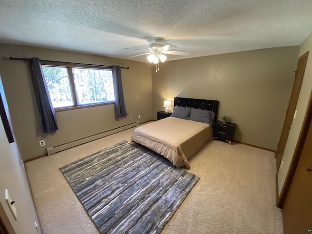 carpeted bedroom with baseboards, a textured ceiling, a baseboard heating unit, and ceiling fan