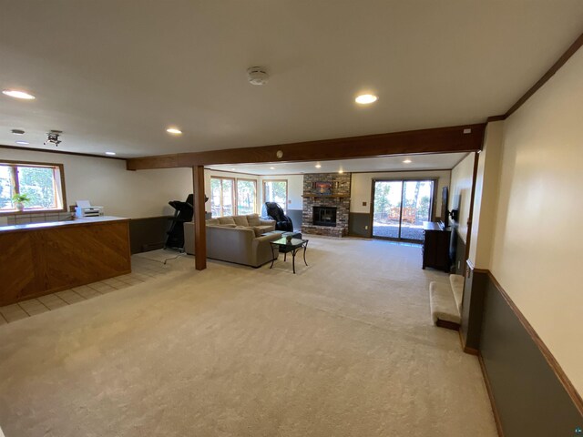 living area featuring a fireplace, beamed ceiling, light carpet, and recessed lighting