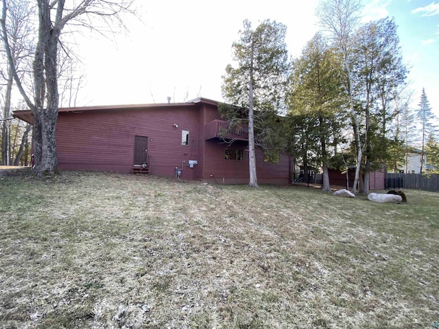 rear view of property with a lawn and fence