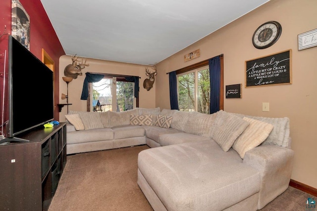 carpeted living room featuring baseboards