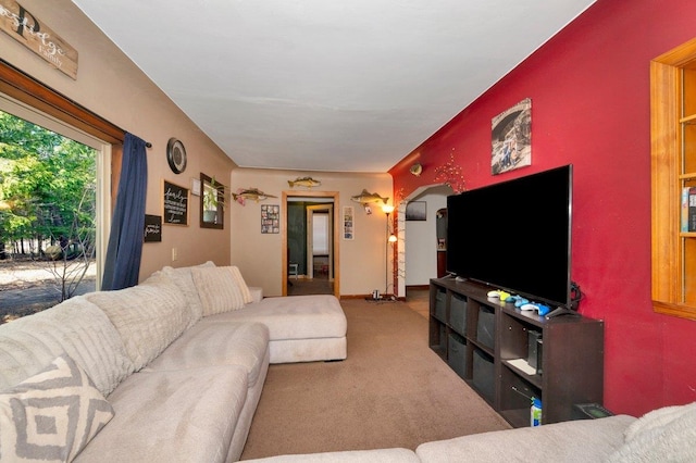living area featuring carpet floors and arched walkways