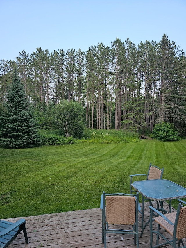view of yard with a deck and outdoor dining space
