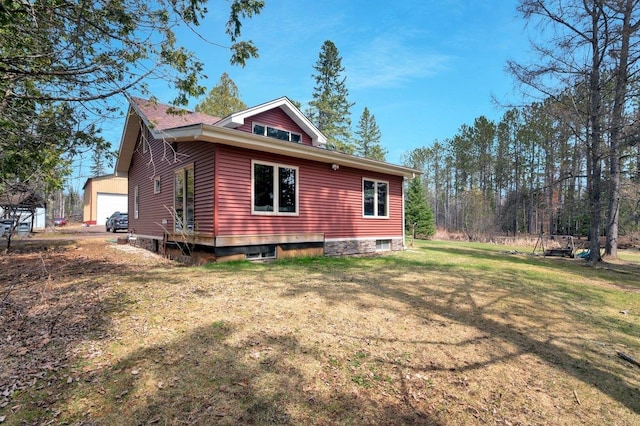 view of side of property featuring a yard and an outdoor structure