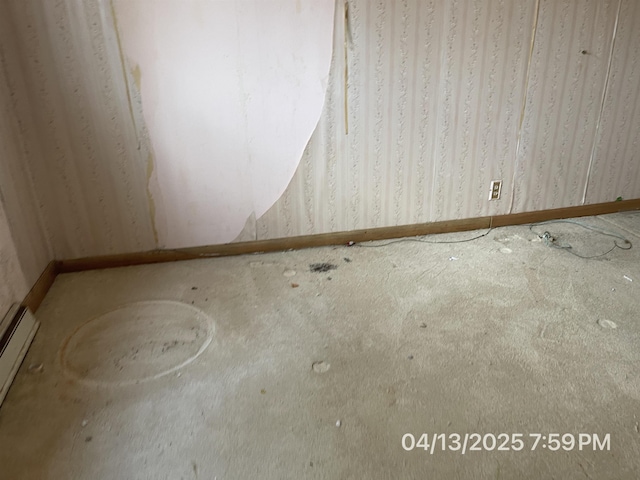 spare room with carpet flooring, wallpapered walls, and a baseboard heating unit