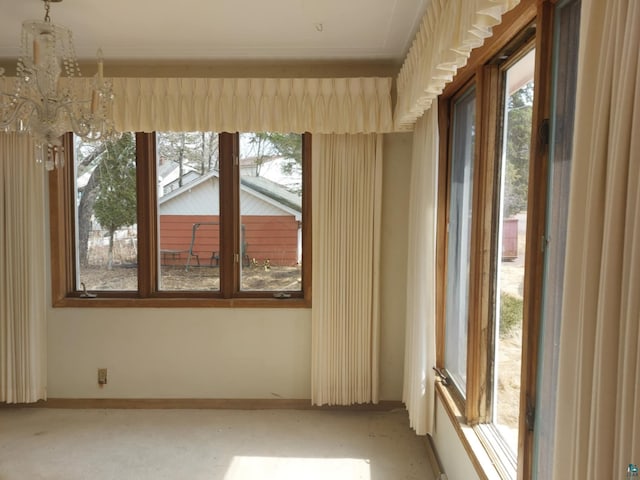 unfurnished room with an inviting chandelier and baseboards