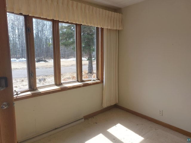 empty room with baseboards, light carpet, and baseboard heating