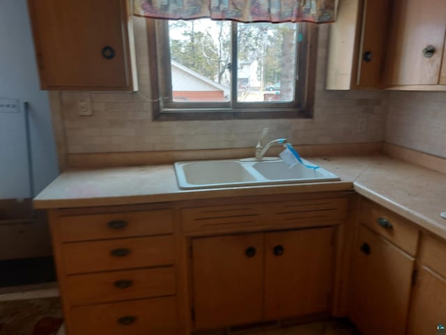 kitchen featuring light countertops, a sink, and tasteful backsplash