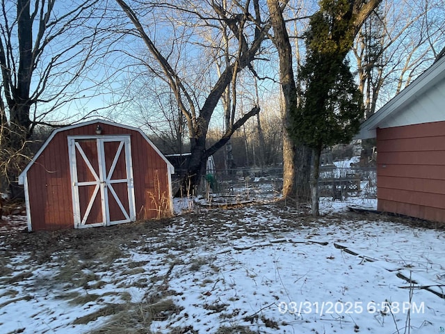 yard layered in snow featuring an outdoor structure and a shed