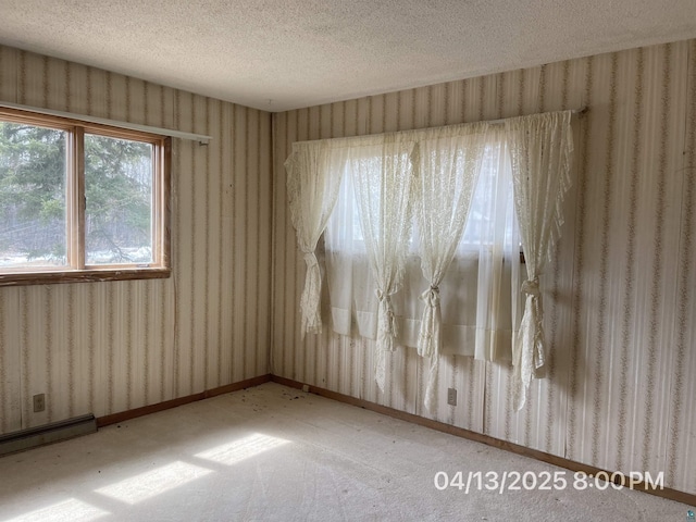 empty room with a textured ceiling, wallpapered walls, light colored carpet, and a baseboard radiator