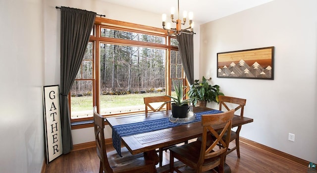 dining space with dark wood-style flooring, baseboards, and a notable chandelier