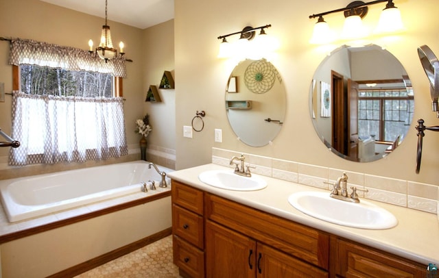 full bathroom with double vanity, a sink, a bath, and a chandelier