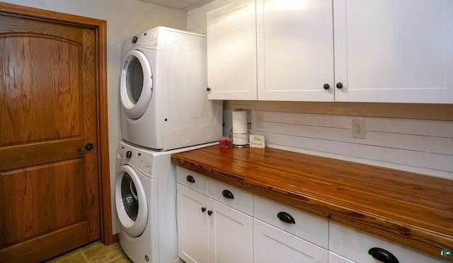 laundry area featuring cabinet space and stacked washer / drying machine