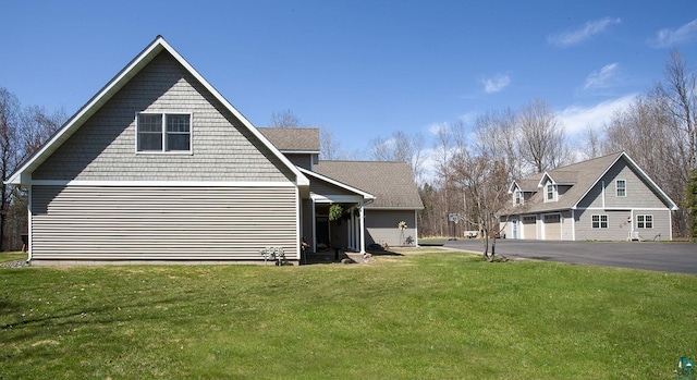 view of side of home featuring a lawn and a garage