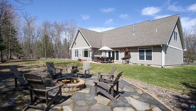 back of house with a yard, a patio, a fire pit, and roof with shingles
