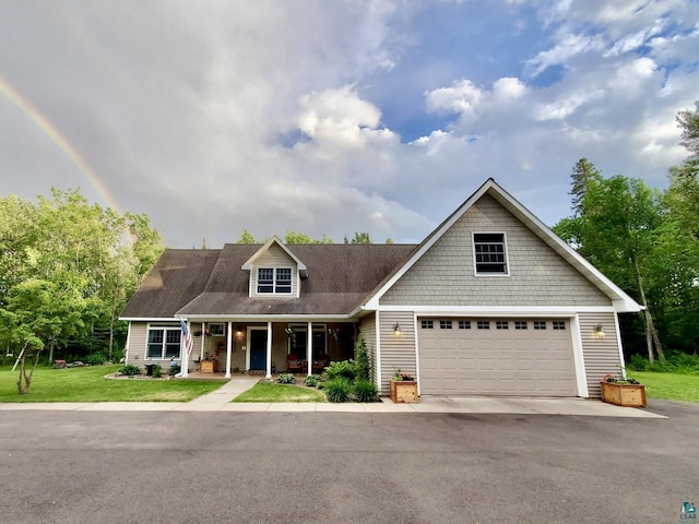 view of front of property with a garage, a front lawn, covered porch, a shingled roof, and driveway