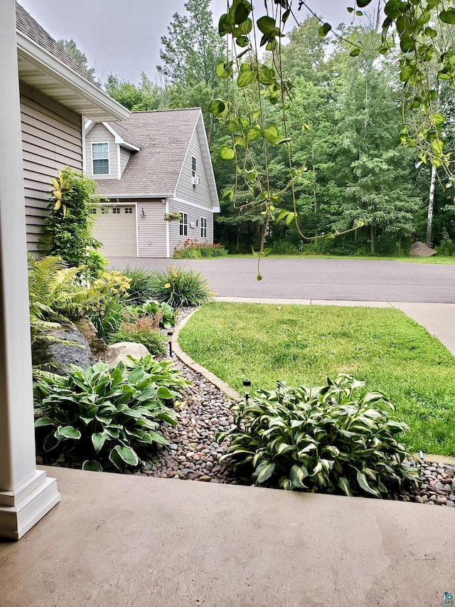 view of yard featuring an attached garage and driveway