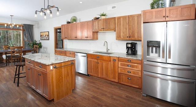 kitchen with decorative backsplash, visible vents, a sink, a chandelier, and stainless steel appliances