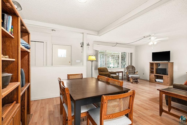 dining area featuring a ceiling fan, a textured ceiling, and light wood finished floors