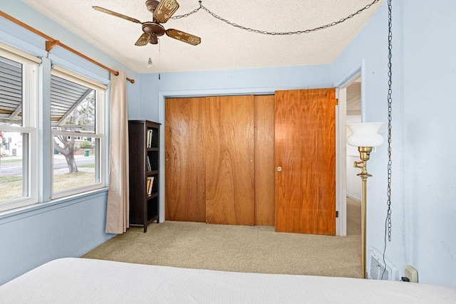 carpeted bedroom with ceiling fan and a closet