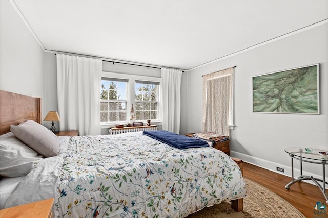 bedroom with baseboards and wood finished floors