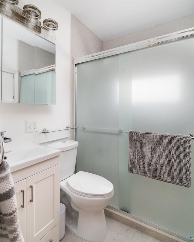 bathroom featuring vanity, a shower stall, and toilet