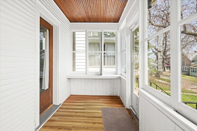 unfurnished sunroom with wood walls, wooden ceiling, and wood finished floors