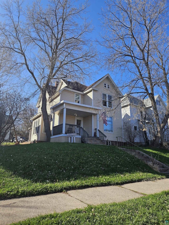 view of front facade with covered porch and a front lawn