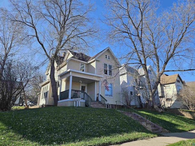 traditional-style house with a porch and a front yard