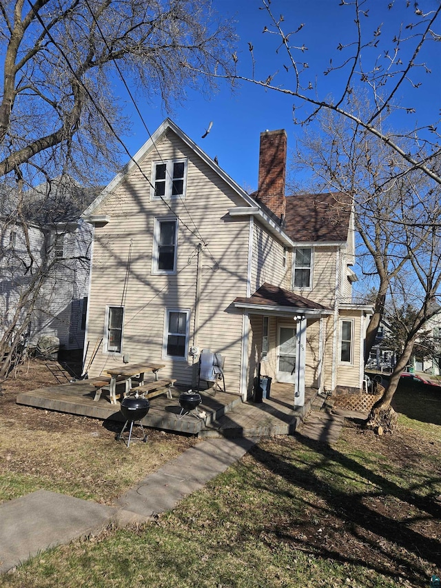 rear view of property featuring a patio and a chimney