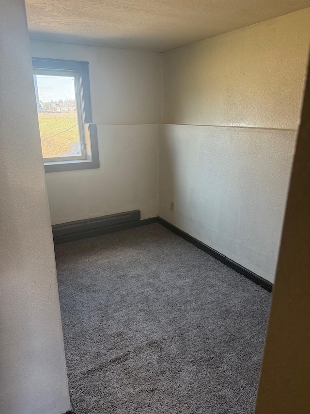 carpeted spare room with baseboards and baseboard heating