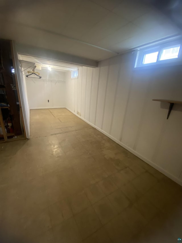 below grade area featuring tile patterned floors and a decorative wall