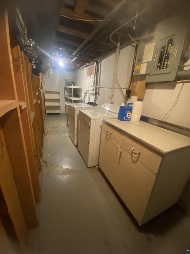 unfinished below grade area featuring electric panel and washing machine and clothes dryer