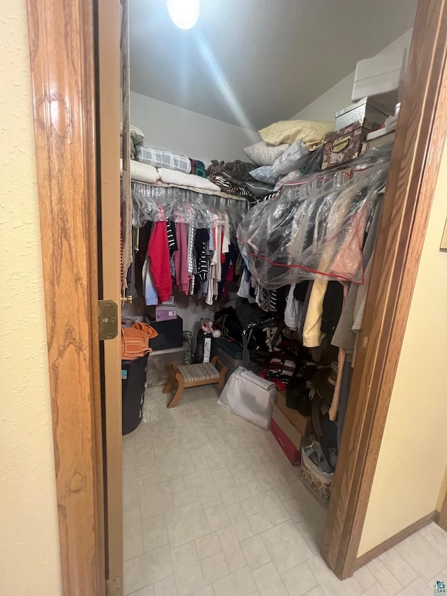 walk in closet with vaulted ceiling and tile patterned floors