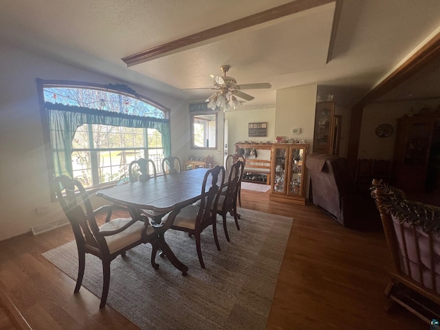 dining room featuring a textured ceiling, baseboards, ceiling fan, vaulted ceiling, and wood finished floors