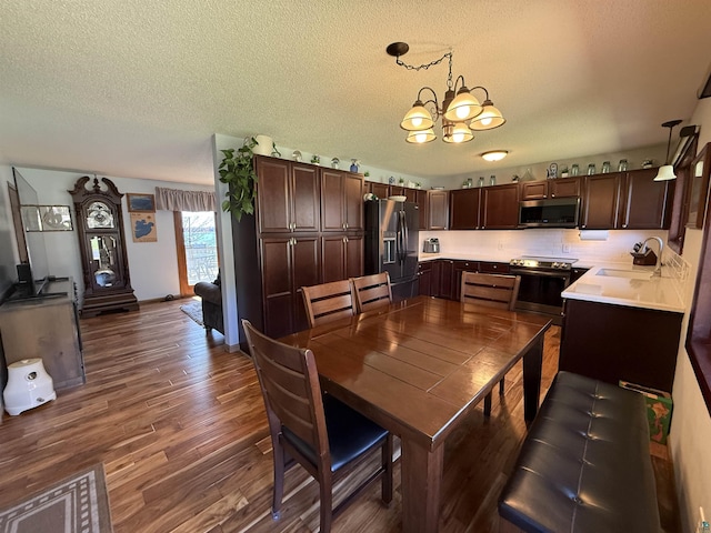 46040 State Highway 65, Nashwauk, MN 55769 - dining area featuring dark wood finished floors, a chandelier, and a textured ceiling