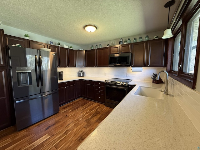 46040 State Highway 65, Nashwauk, MN 55769 - kitchen featuring a sink, dark wood finished floors, light countertops, dark brown cabinets, and appliances with stainless steel finishes