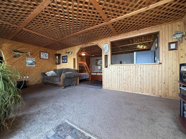 46040 State Highway 65, Nashwauk, MN 55769 - living room featuring arched walkways, carpet flooring, and wood walls