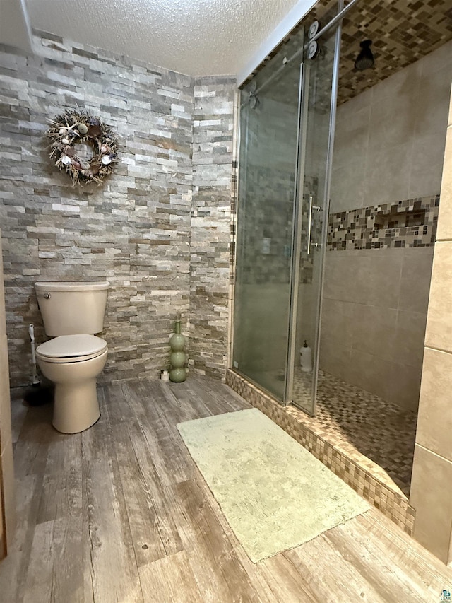 46040 State Highway 65, Nashwauk, MN 55769 - full bath featuring toilet, a textured ceiling, a shower stall, and wood finished floors