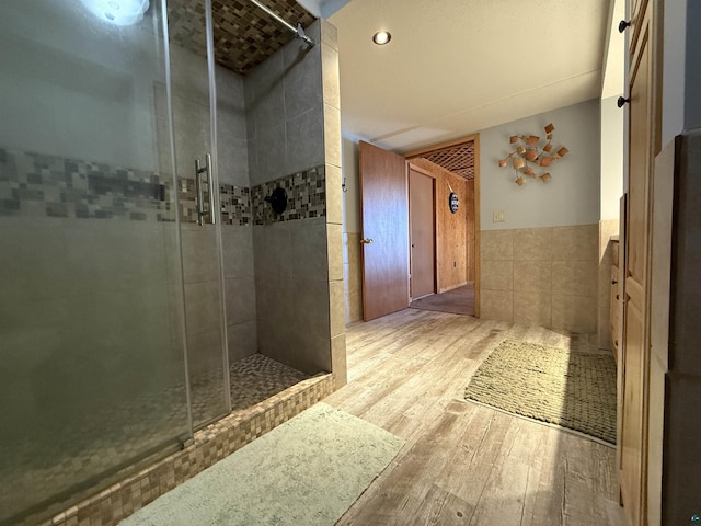 46040 State Highway 65, Nashwauk, MN 55769 - full bath featuring a stall shower, tile walls, wainscoting, and wood finished floors