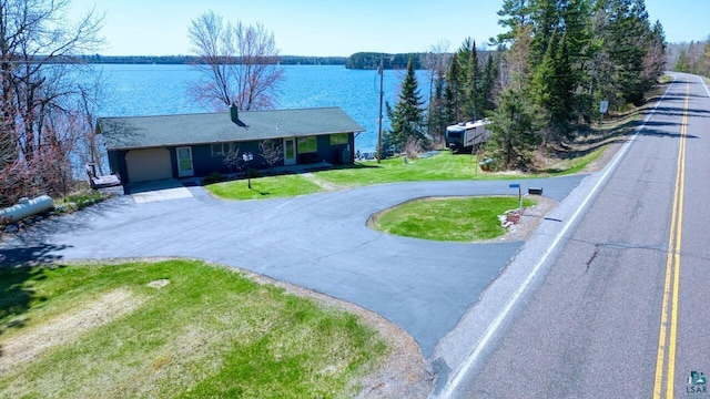 46040 State Highway 65, Nashwauk, MN 55769 - view of front of house with curved driveway, a water view, a garage, and a front yard
