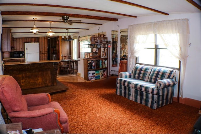 living room with carpet, a ceiling fan, and beamed ceiling