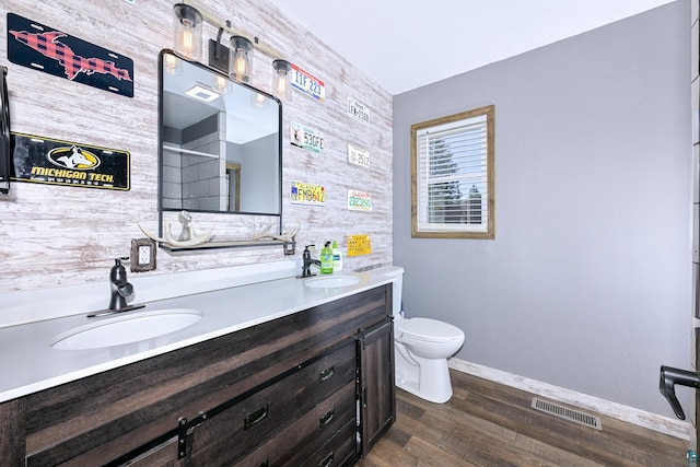 bathroom featuring double vanity, toilet, visible vents, and a sink