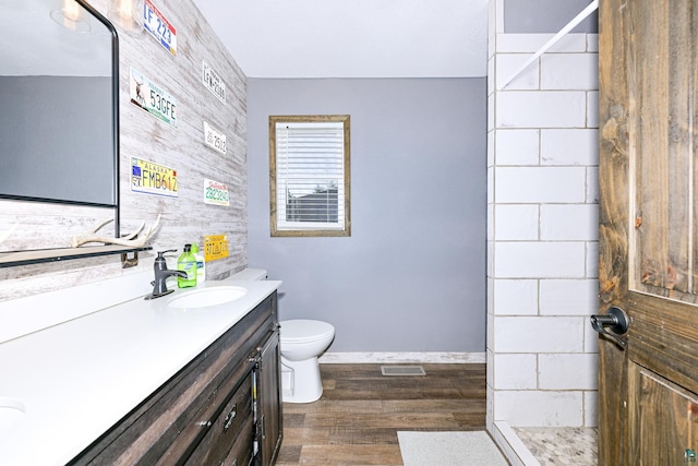 full bathroom featuring toilet, wood finished floors, visible vents, baseboards, and vanity