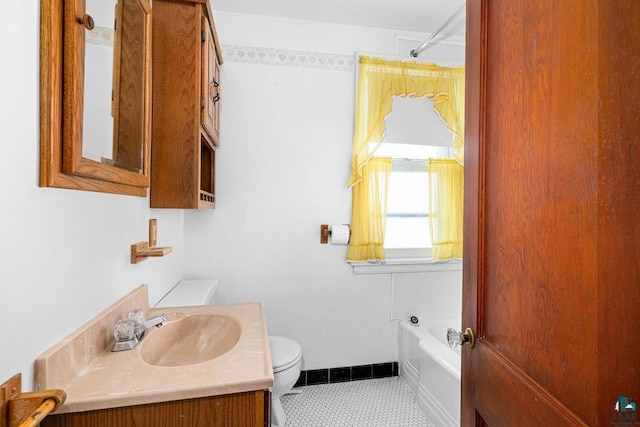 bathroom featuring toilet, baseboards, a tub to relax in, tile patterned flooring, and vanity