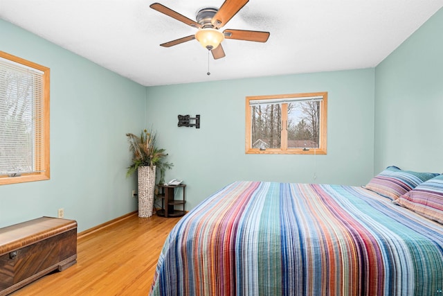 bedroom with baseboards, ceiling fan, and wood finished floors