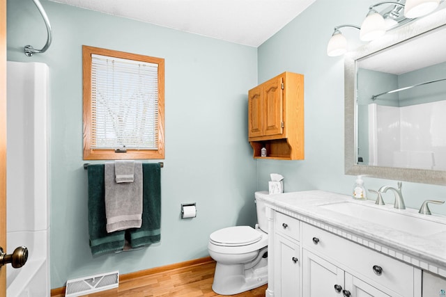 full bathroom with toilet, a shower, wood finished floors, vanity, and visible vents