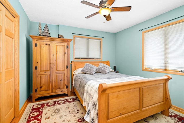 bedroom featuring baseboards, a ceiling fan, and light wood-style floors