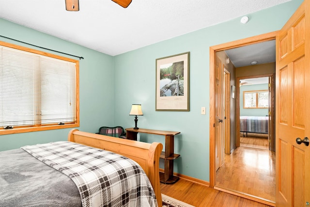 bedroom featuring baseboards, ceiling fan, and light wood-type flooring